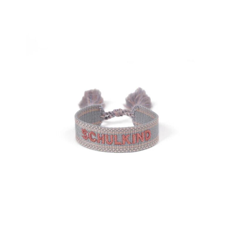leevjearmband Beaded bracelet with the word SCHULKIND embroidered in red on a pale band and two tassels at the ends.
